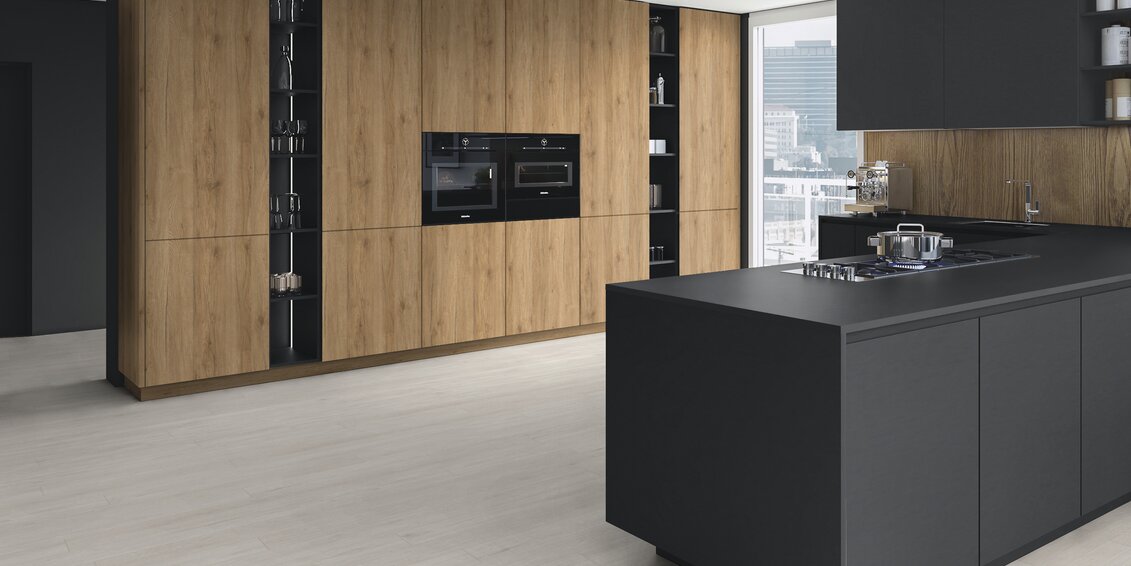 Designerküche mit schwarzer Kochinsel, Holzfronten, integrierten Elektrogeräten und modernem Stauraumkonzept in stilvollem Loft-Ambiente.