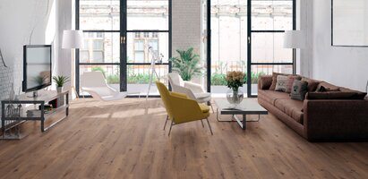 Helles Wohnzimmer mit Parkettboden und einer offenen Balkontür