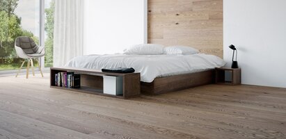 Helles, modernes Schlafzimmer mit Massivholzboden und einem zentralen großen Doppelbett