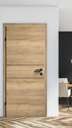CPL-Innentür im Dekor Eiche Wave quer mit schwarzen Lisenen und passender schwarzer Griffgarnitur, eingebaut in einen modernen Wohnraum mit Fischgrätboden.