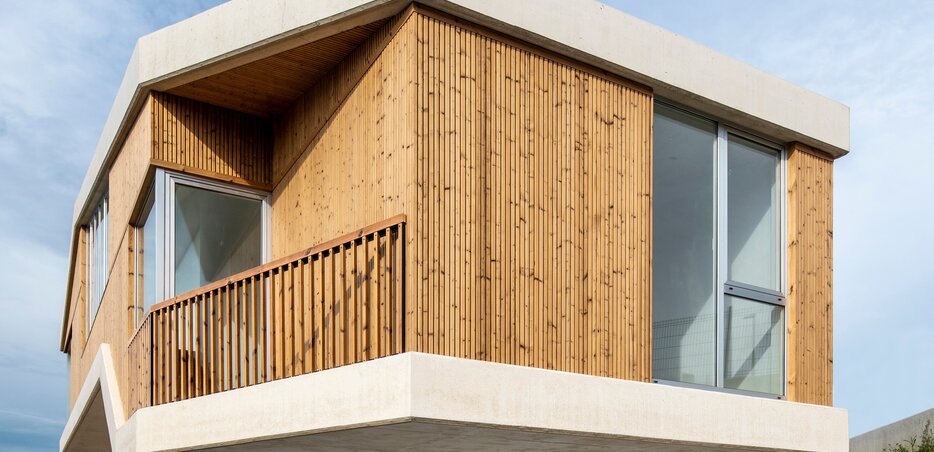 Fassade mit Lunawood Triple Profilen, kombiniert mit Sichtbeton und großen Fensterelementen in modernem Design. | © Lunawood