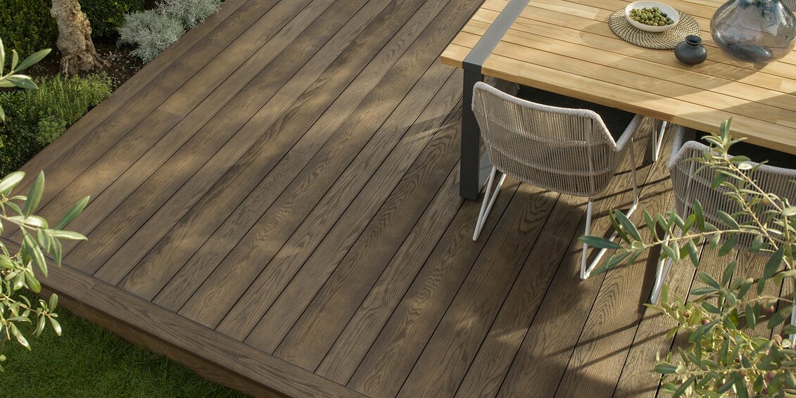 Weitwinkelaufnahme einer modernen Terrasse im System „AO-SB“ mit gleichmäßig verlegten Dielen, warmer Holzfarbe und harmonischer Integration in den Außenbereich – ideal für stilvolle Outdoor-Lösungen. | © Millboard
