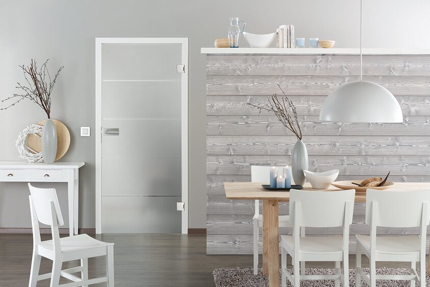 Moderne Glastür mit satiniertem Dekor und Edelstahlbeschlägen Innenaufnahme einer eleganten Glastür mit satiniertem Dekor in horizontalen Streifen. Die Tür ist rahmenlos, mit modernen Edelstahlbeschlägen und einem schlichten Griff ausgestattet. Sie trennt zwei helle Wohnbereiche und lässt viel Licht hindurch, wodurch ein offenes und freundliches Raumgefühl entsteht. Die Gestaltung wirkt modern, transparent und stilvoll.