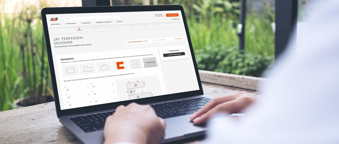 Das Bild zeigt eine Person im Freien, die einen Laptop benutzt. Auf dem Bildschirm ist die Webseite „JAF TERRASSEN-DESIGNER“ mit Gestaltungselementen, Maßen und Diagrammen zur Terrassenplanung zu sehen.