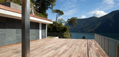 Villa mit einer Massivholzterrasse am See in den Bergen.