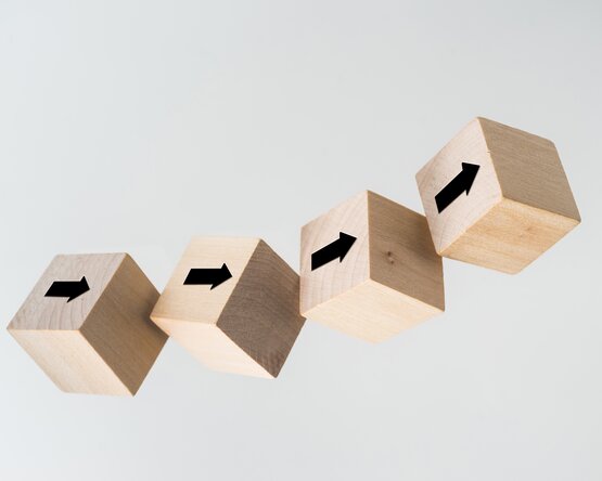 Fünf Holzwürfel mit Pfeilen darauf