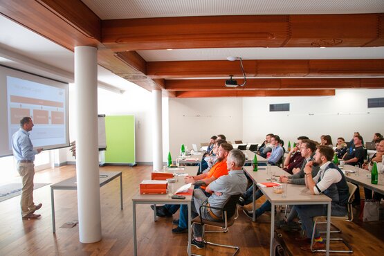 Vortrag vor einer Gruppe Mann hält vor einem Smartboard einen Vortrag vor einer Gruppe von Menschen
