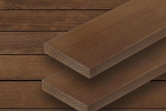 Terrassendielen aus Holz Zwei parallele Terrassendielen mit sichtbarer Maserung liegen auf einer Fläche aus ähnlichem Holz mit horizontalen Brettern im Hintergrund.