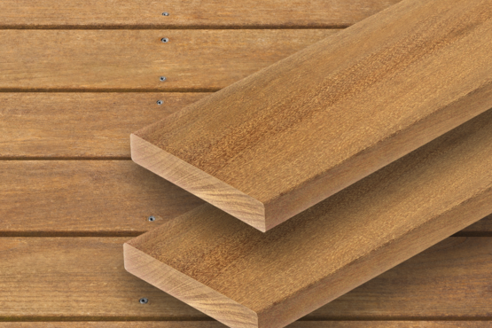 Terrassendielen aus Holz Zwei braune parallele Terrassendielen mit sichtbarer Maserung liegen auf einer Fläche aus ähnlichem Holz mit horizontalen Brettern im Hintergrund.