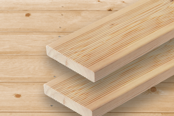 Terrassendielen aus Holz Zwei hellbraune parallele Terrassendielen mit sichtbarer Maserung und Riffelung liegen auf einer Fläche aus ähnlichem Holz mit horizontalen Brettern im Hintergrund.