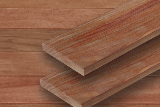 Terrassendielen aus Holz Zwei dunkelbraune parallele Terrassendielen mit sichtbarer Maserung liegen auf einer Fläche aus ähnlichem Holz mit horizontalen Brettern im Hintergrund.