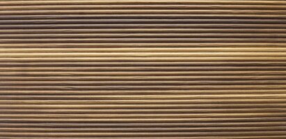 Nahaufnahme einer Oberfläche mit gleichmäßigen, horizontal verlaufenden Rillen, ähnlich wie bei Wellpappe oder einem strukturierten Material.