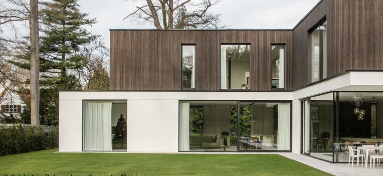 Zweistöckiges Wohnhaus mit moderner vertikaler Holzfassade im Obergeschoss und großen Glasfronten | © SelsLatem Debruyckere, Carpentier/Belgique