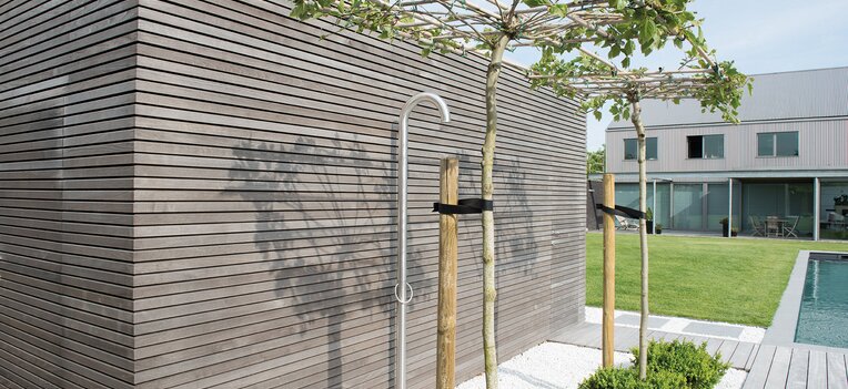 Garten mit Pool, jungen Bäumen und stilvoller Fassadengestaltung aus Holz. | © Thermory 