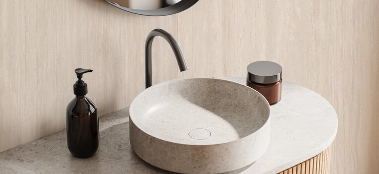 Modernes Badezimmer mit hellem Wandpaneel in Natursteinoptik hinter rundem Spiegel und Aufsatzwaschbecken. | © Kronospan