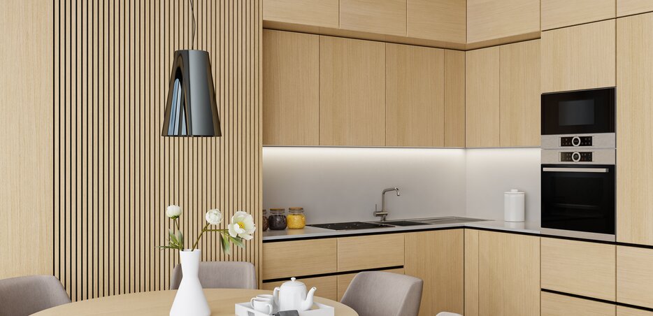 Moderne Küche in heller Holzoptik mit indirekter LED-Beleuchtung unter den Oberschränken und Essplatz